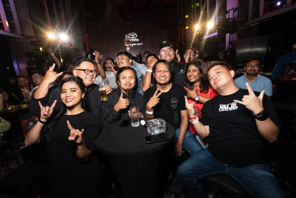 Group of corporate guests posing enthusiastically at Toyota indoor evening event
